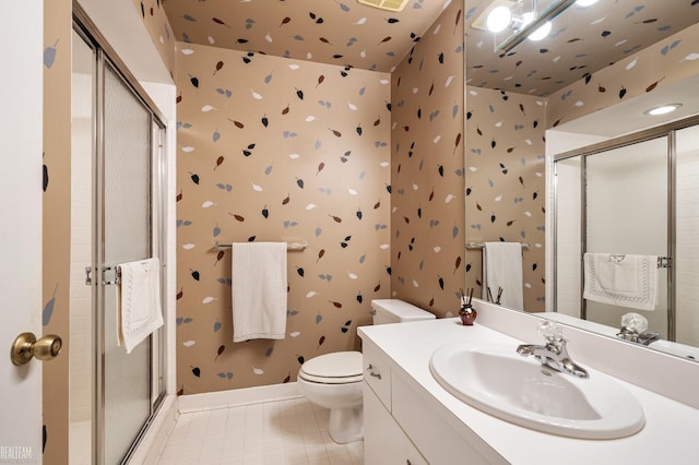 bathroom featuring tile patterned flooring, toilet, vanity, a shower stall, and wallpapered walls