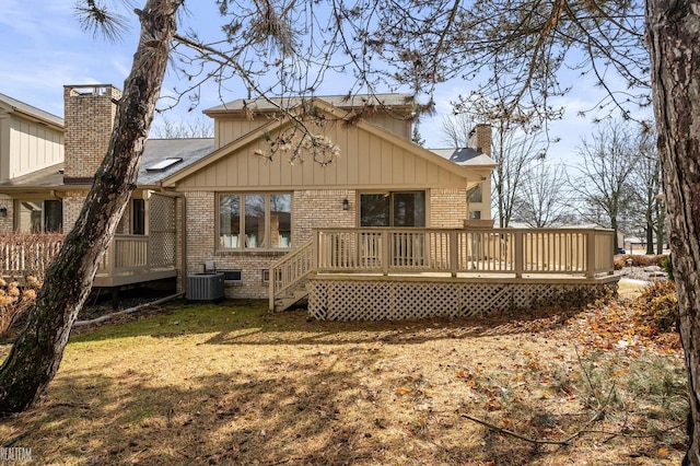 back of house featuring a deck, brick siding, a chimney, and central AC unit