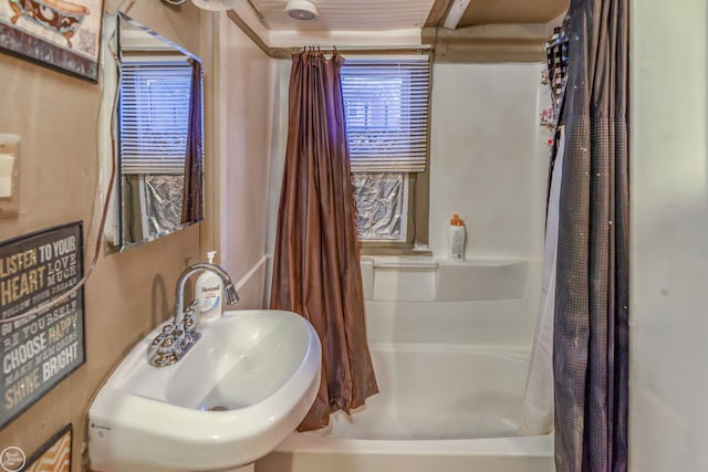 bathroom featuring shower / bath combination with curtain and a sink