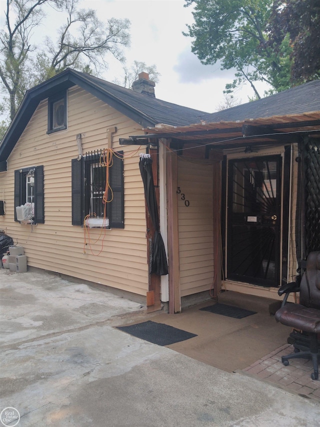 view of home's exterior with a chimney and a patio area