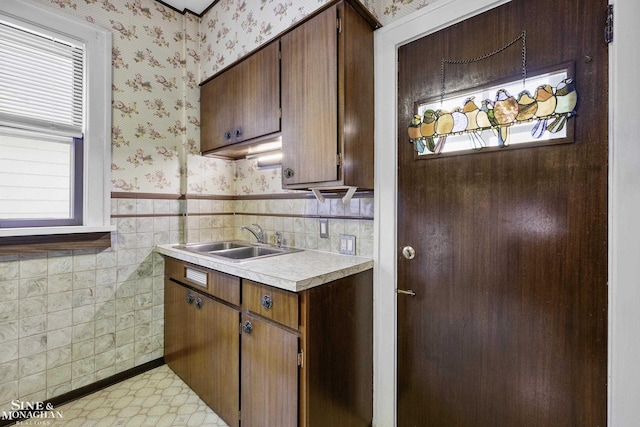 kitchen with wallpapered walls, light countertops, and a wealth of natural light