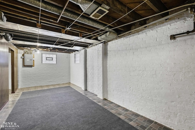 below grade area with brick wall and electric panel