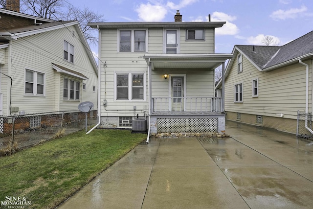 rear view of property with a porch, cooling unit, fence, a lawn, and a chimney