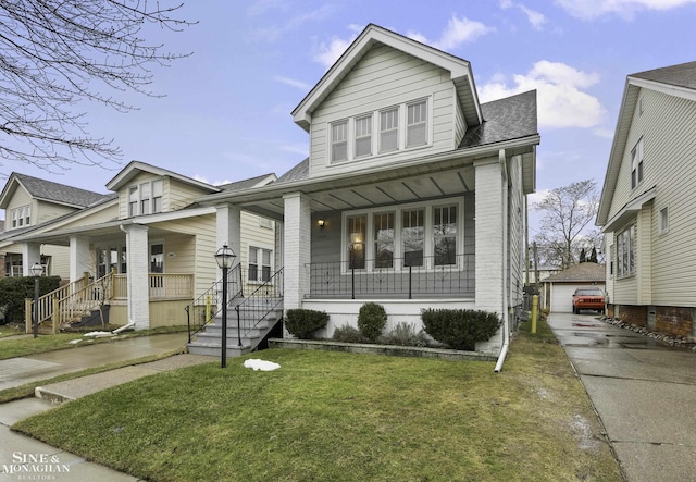 view of front facade featuring covered porch, roof with shingles, an outdoor structure, and a front yard