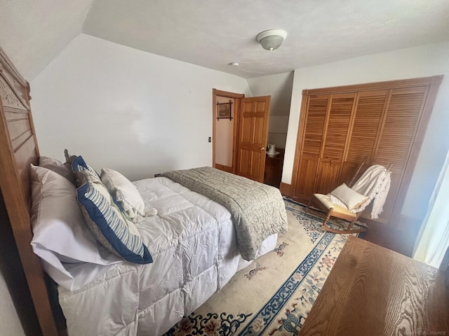 bedroom with vaulted ceiling and a closet