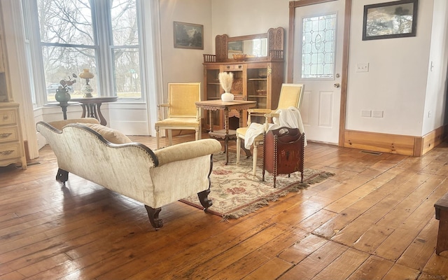 living area featuring hardwood / wood-style floors, plenty of natural light, and baseboards