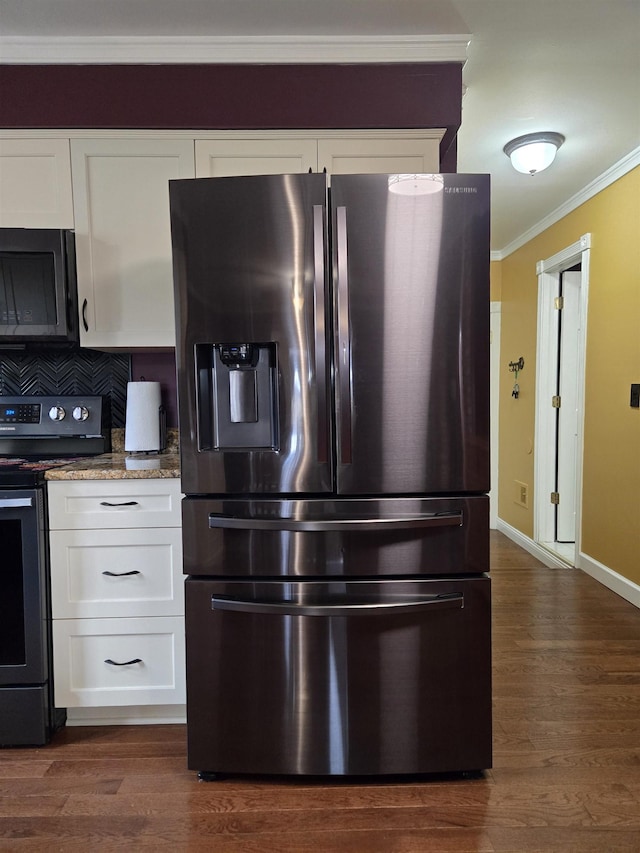 kitchen with stainless steel appliances, ornamental molding, dark wood-type flooring, and white cabinets