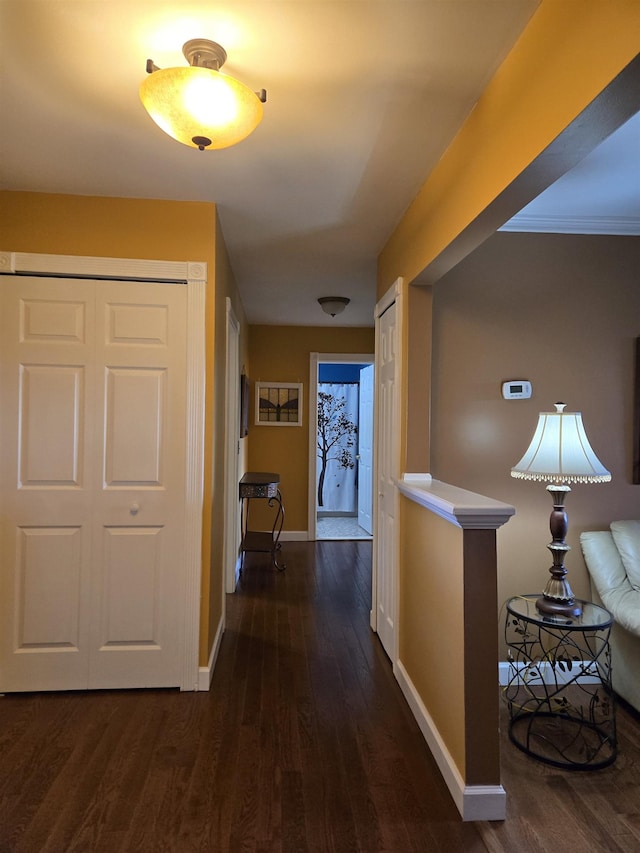 corridor with baseboards and dark wood finished floors