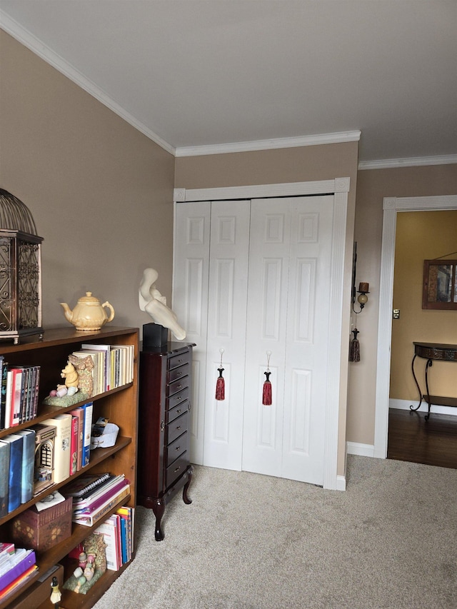 carpeted bedroom with baseboards, ornamental molding, and a closet