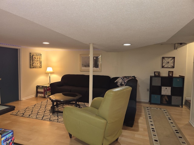 living room with a textured ceiling, light wood-type flooring, and recessed lighting