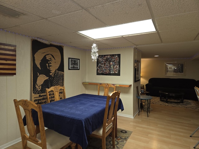 dining room with light wood-style floors and a paneled ceiling