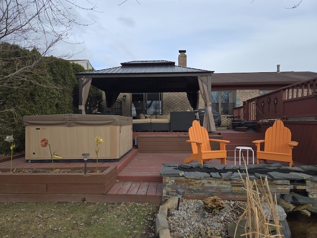 wooden terrace featuring a hot tub and a gazebo