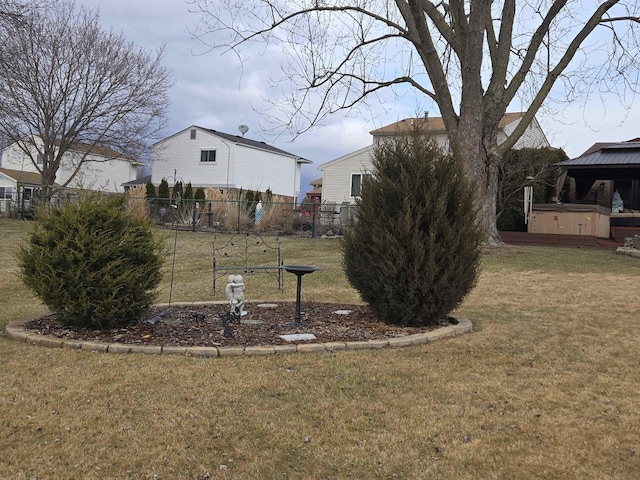 view of yard featuring fence and a hot tub