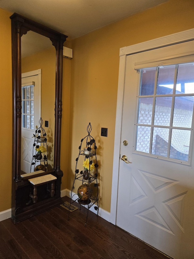 doorway featuring dark wood-style flooring, baseboards, and ornate columns