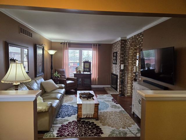 living area with a fireplace, visible vents, dark wood-style flooring, and ornamental molding