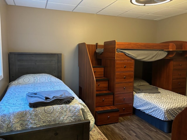 bedroom featuring dark wood-type flooring and a drop ceiling