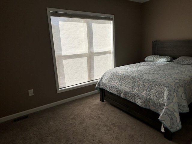 bedroom featuring carpet, multiple windows, visible vents, and baseboards