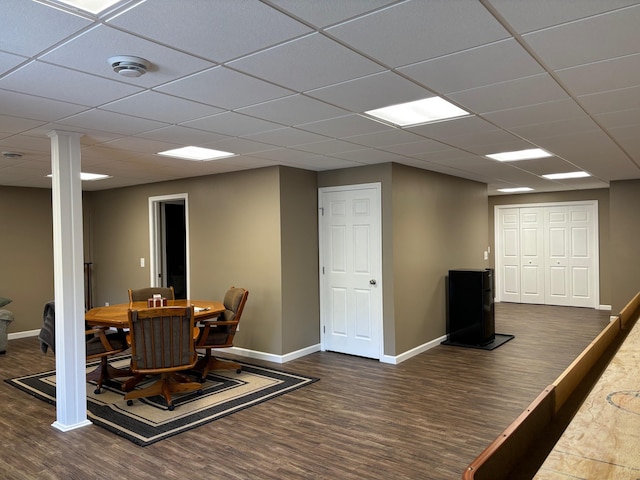 dining room with a drop ceiling, baseboards, and wood finished floors