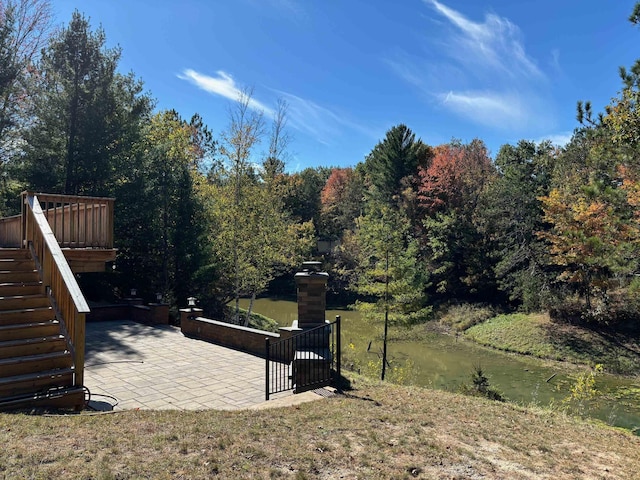 view of yard featuring a patio area, stairway, and a forest view