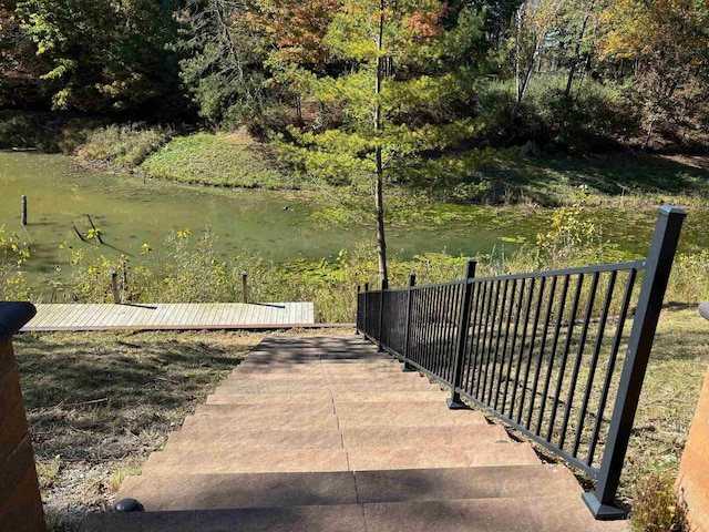 surrounding community featuring a water view and fence