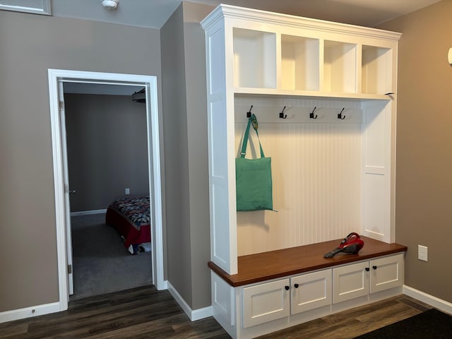 mudroom featuring dark wood-type flooring and baseboards