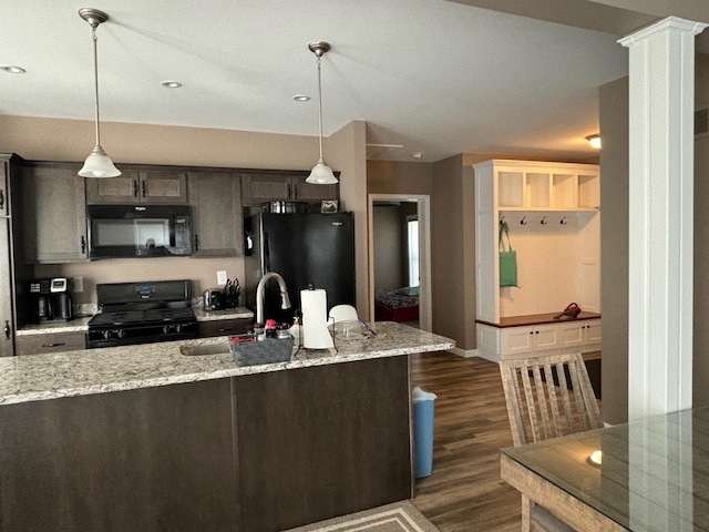 kitchen with dark wood finished floors, pendant lighting, a sink, and black appliances