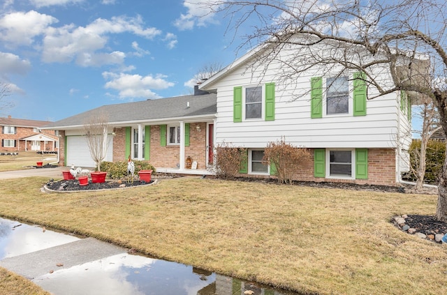 tri-level home featuring brick siding, a chimney, an attached garage, driveway, and a front lawn