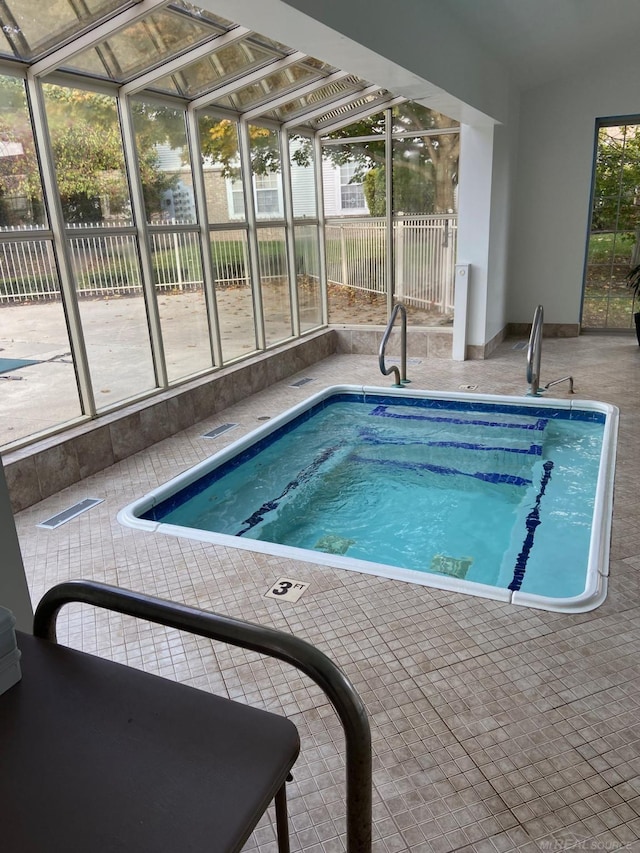 view of swimming pool with glass enclosure and a patio