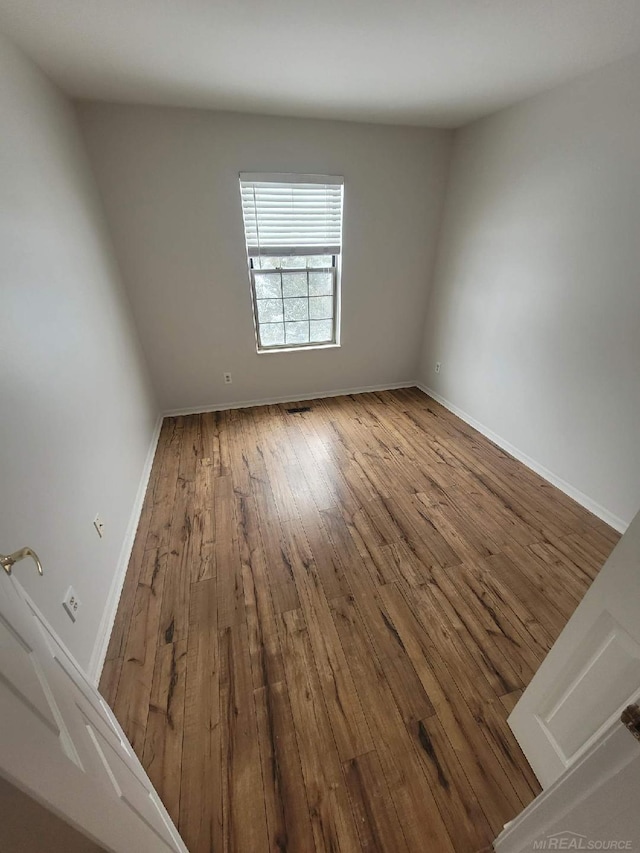 empty room featuring wood-type flooring and baseboards