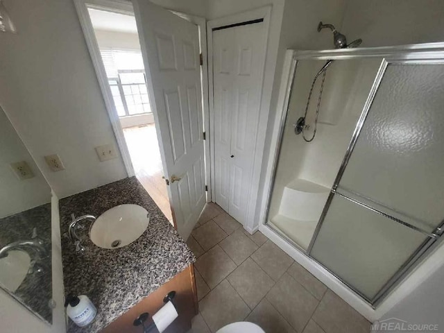 bathroom with a stall shower, tile patterned flooring, and vanity