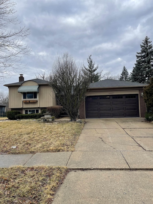 view of front facade featuring a garage, driveway, and a chimney