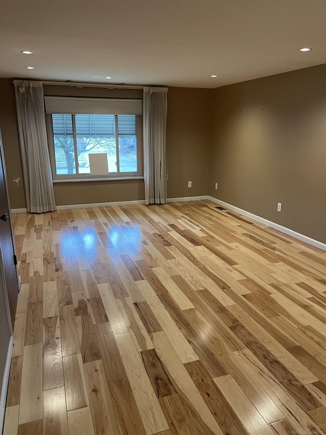 unfurnished room featuring light wood finished floors, baseboards, and recessed lighting