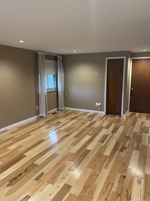 unfurnished room featuring recessed lighting, light wood-style flooring, and baseboards