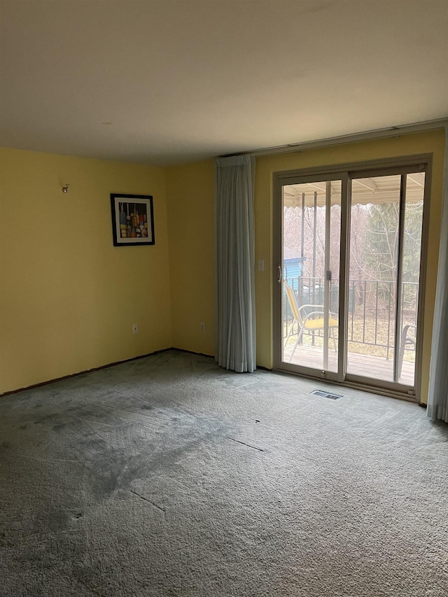 carpeted spare room featuring visible vents