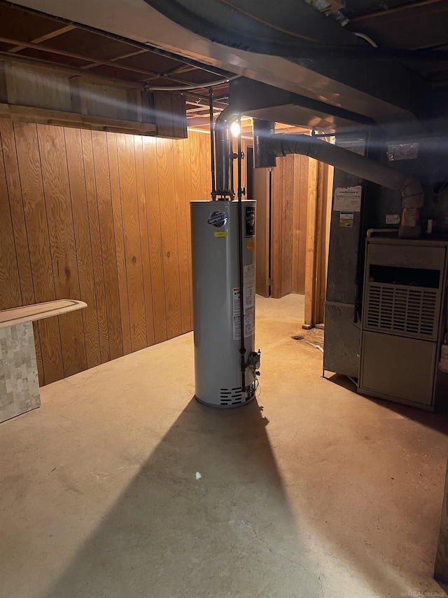 unfinished below grade area featuring heating unit, wooden walls, and gas water heater