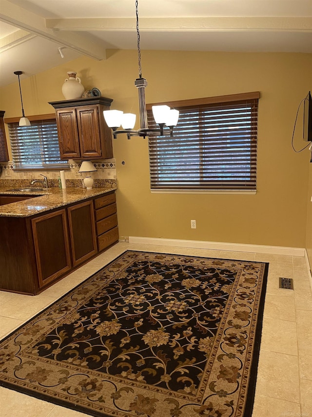 kitchen featuring a chandelier, baseboards, visible vents, and vaulted ceiling with beams