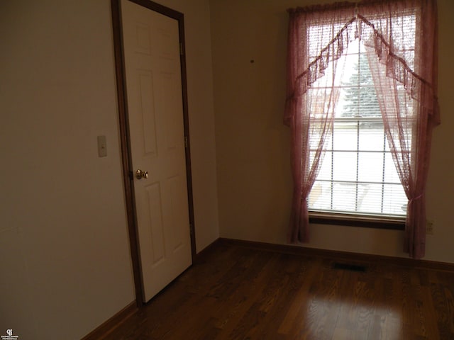 interior space with visible vents, baseboards, and wood finished floors