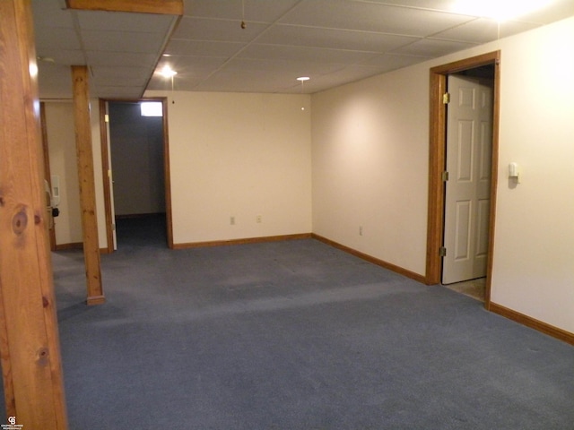 finished below grade area with carpet floors, a drop ceiling, and baseboards