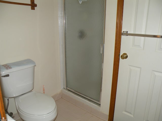 bathroom featuring a shower stall and toilet