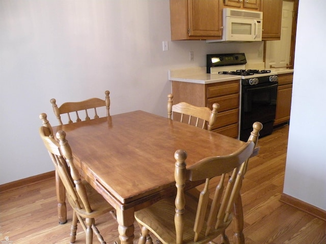 dining area featuring baseboards and light wood-style floors