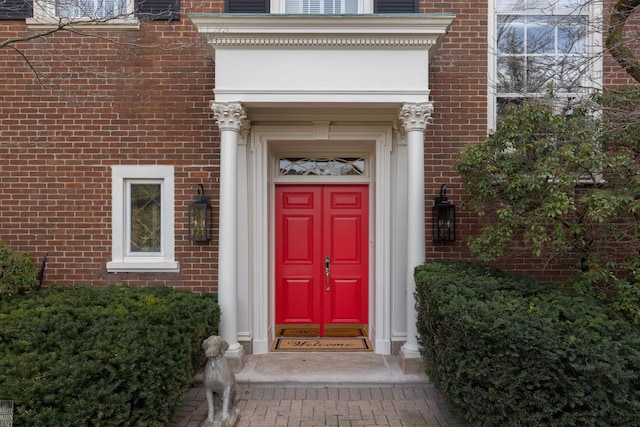 entrance to property featuring brick siding