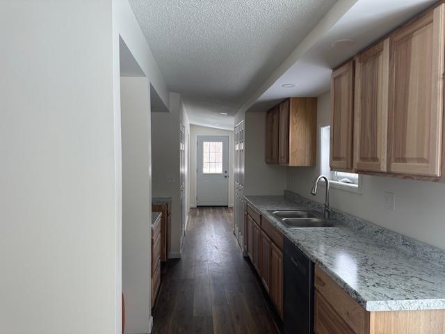 kitchen featuring dishwasher, dark wood-style floors, light countertops, a textured ceiling, and a sink