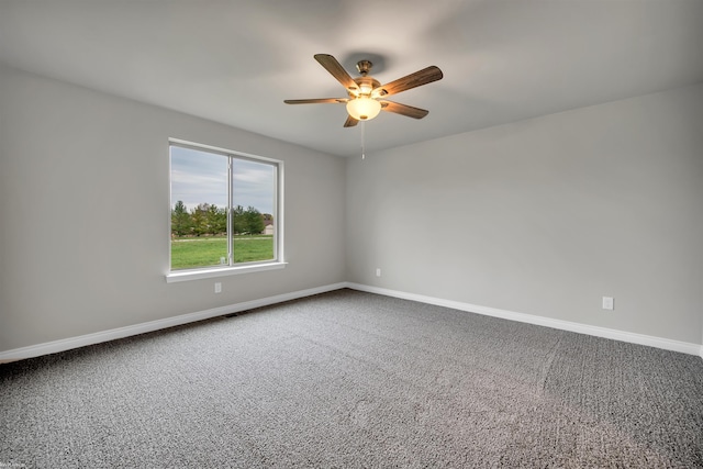 spare room with carpet, a ceiling fan, and baseboards