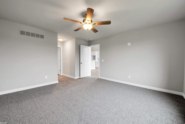 spare room with ceiling fan, carpet flooring, visible vents, and baseboards