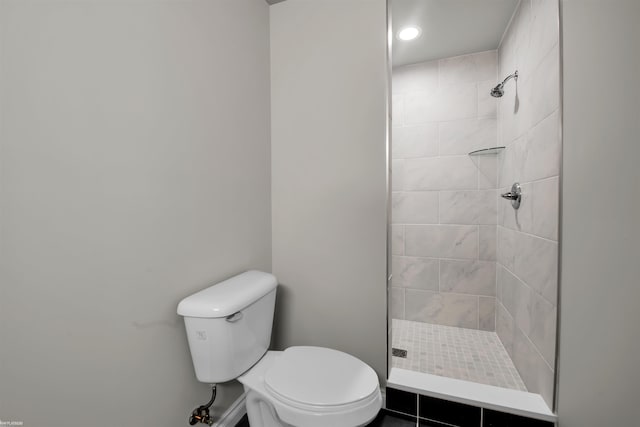 bathroom with toilet and a tile shower