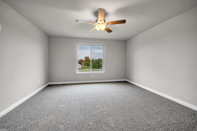 carpeted empty room featuring a ceiling fan and baseboards