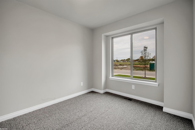 carpeted empty room featuring visible vents and baseboards