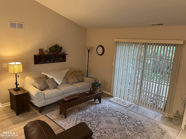 living area with wood finished floors, visible vents, and baseboards