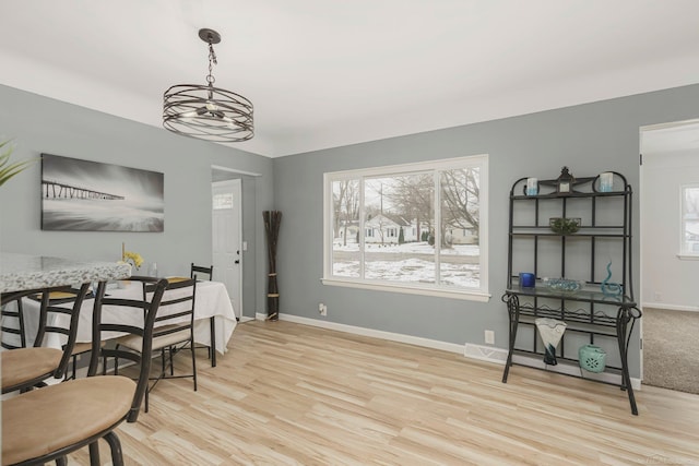 dining area with baseboards, a wealth of natural light, and wood finished floors