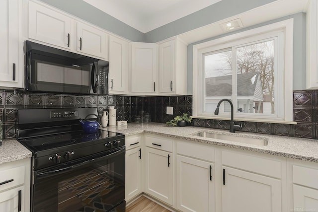 kitchen featuring black appliances, a sink, and decorative backsplash